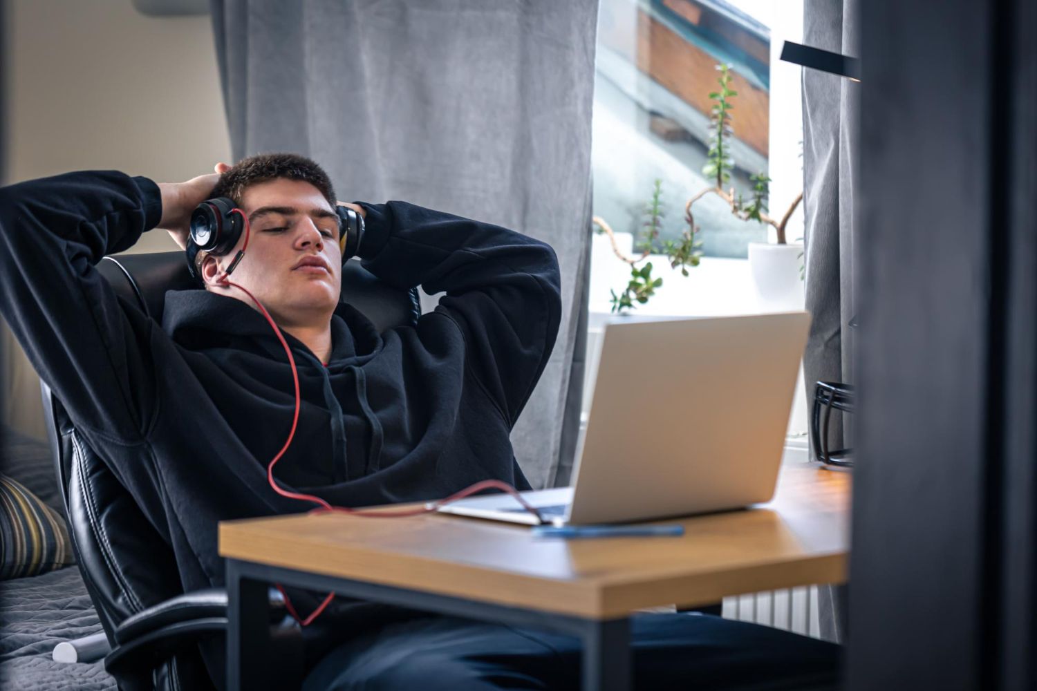 A tired teenager guy in headphones