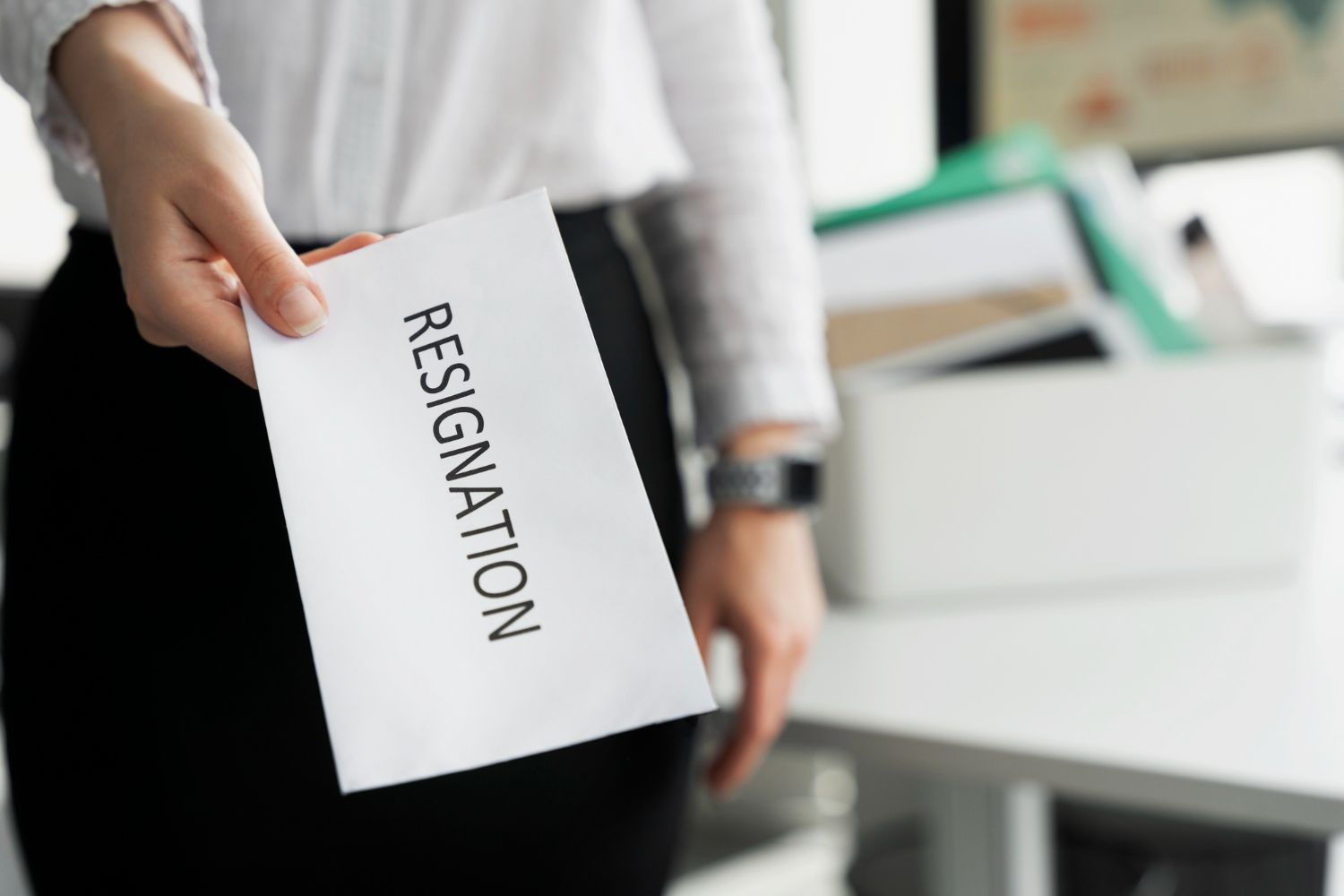 Hand holding resignation note