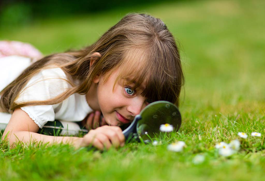 A girl looking through a magnifier out of curiosity