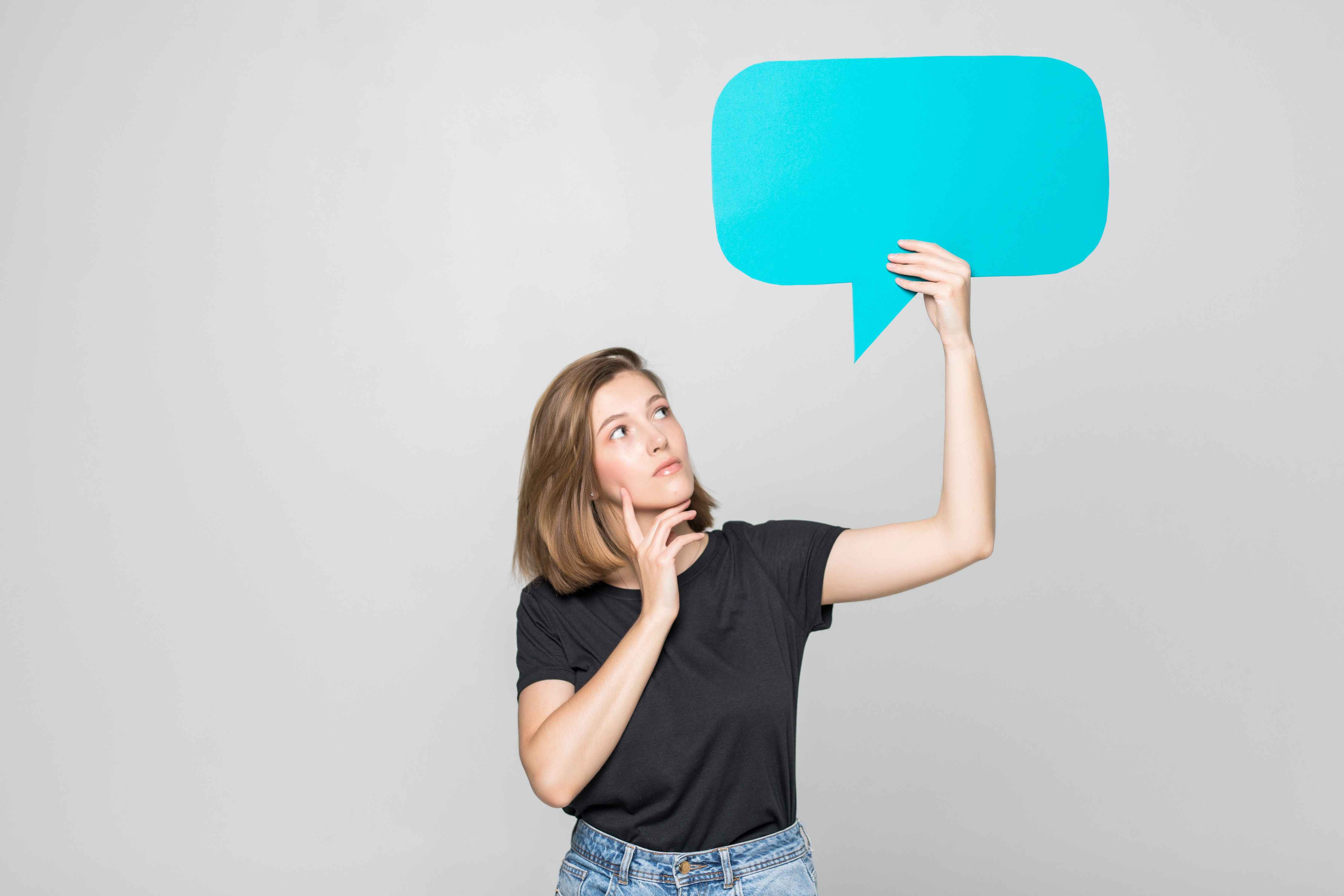 woman holding blank blue speech bubble