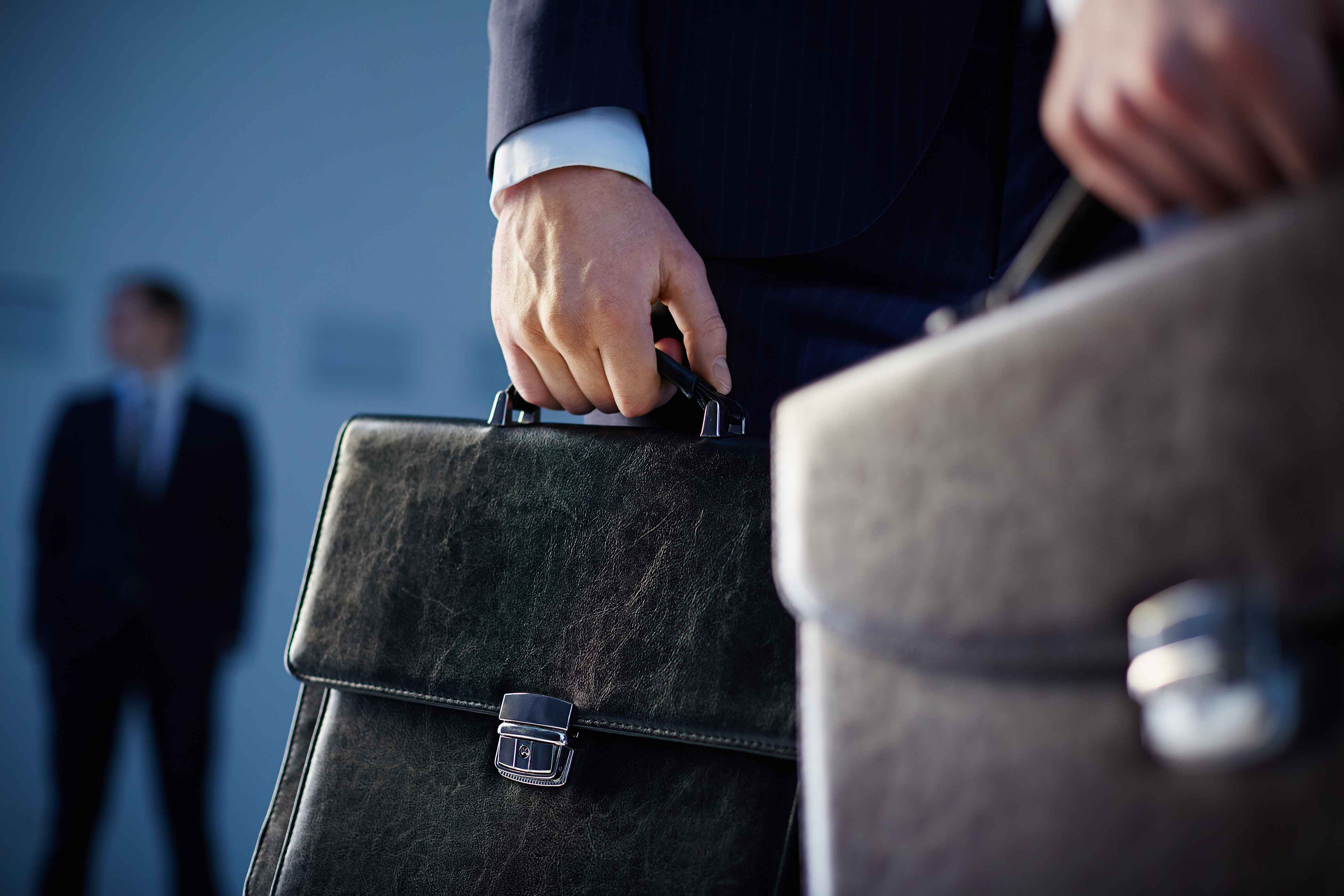 men in suit holding briefcases