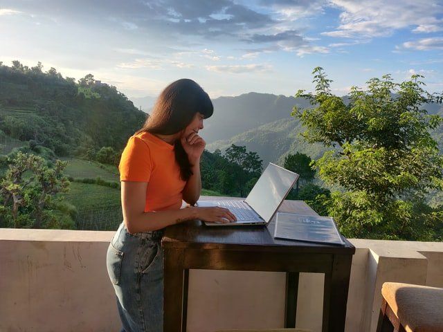 woman enjoying her work-life balance by working in nature