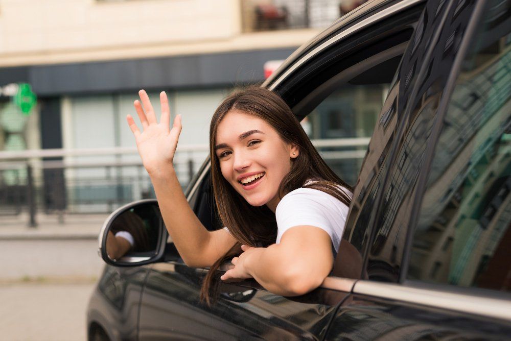 A girl is looking back at her past while waving and smiling. 