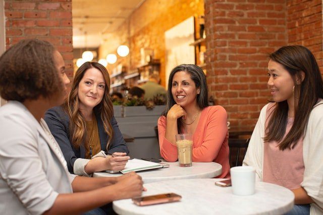 Diverse team of women having a business meeting in a cafe coffee shop