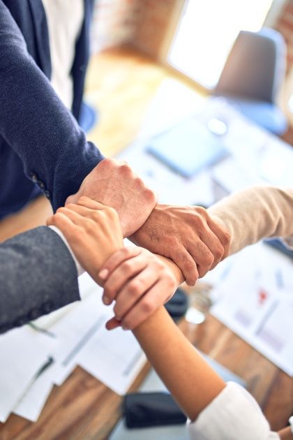 person in black long sleeves holding the other persons hand depicting trust and loyalty in a team