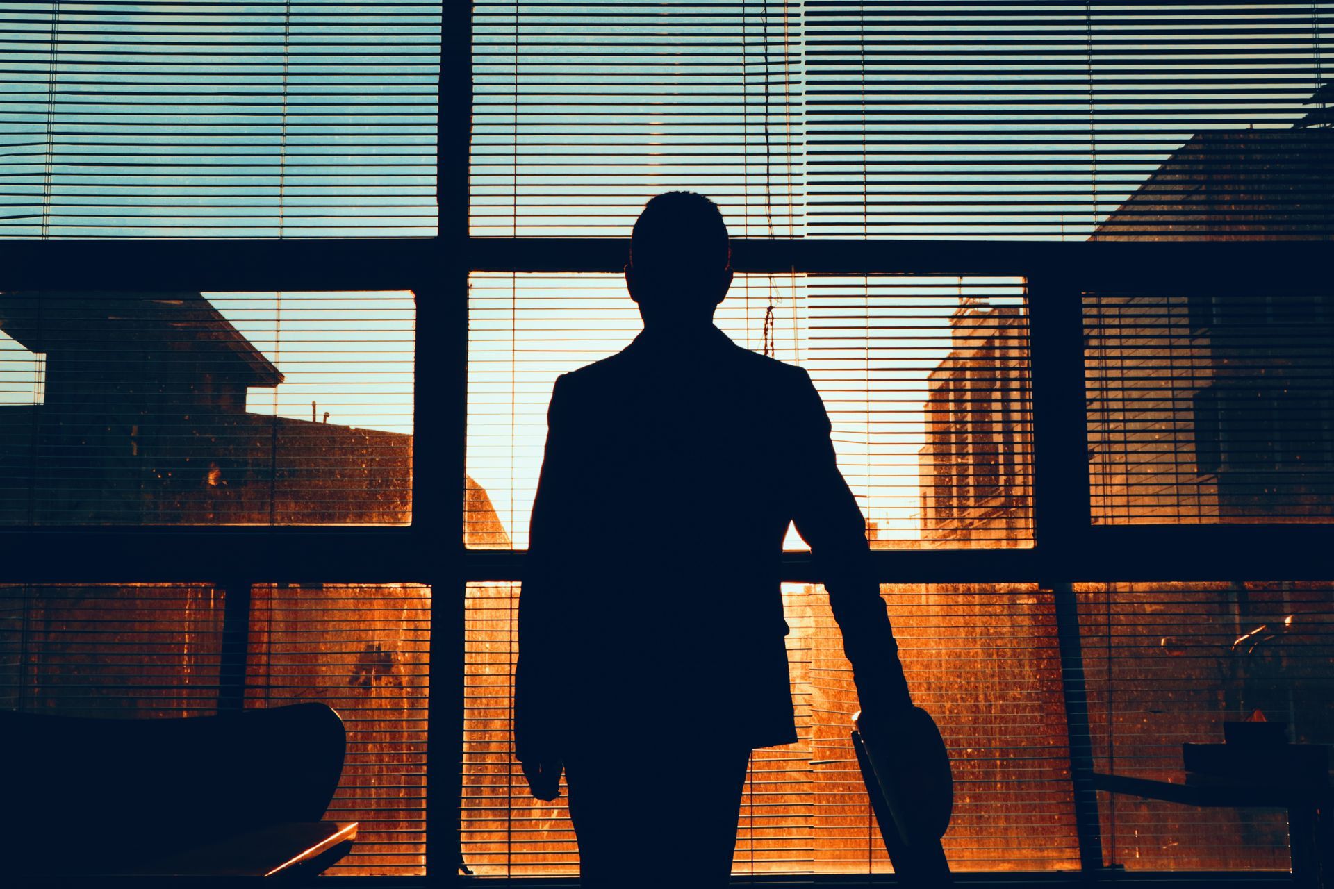 Silhouette of a man standing by a window