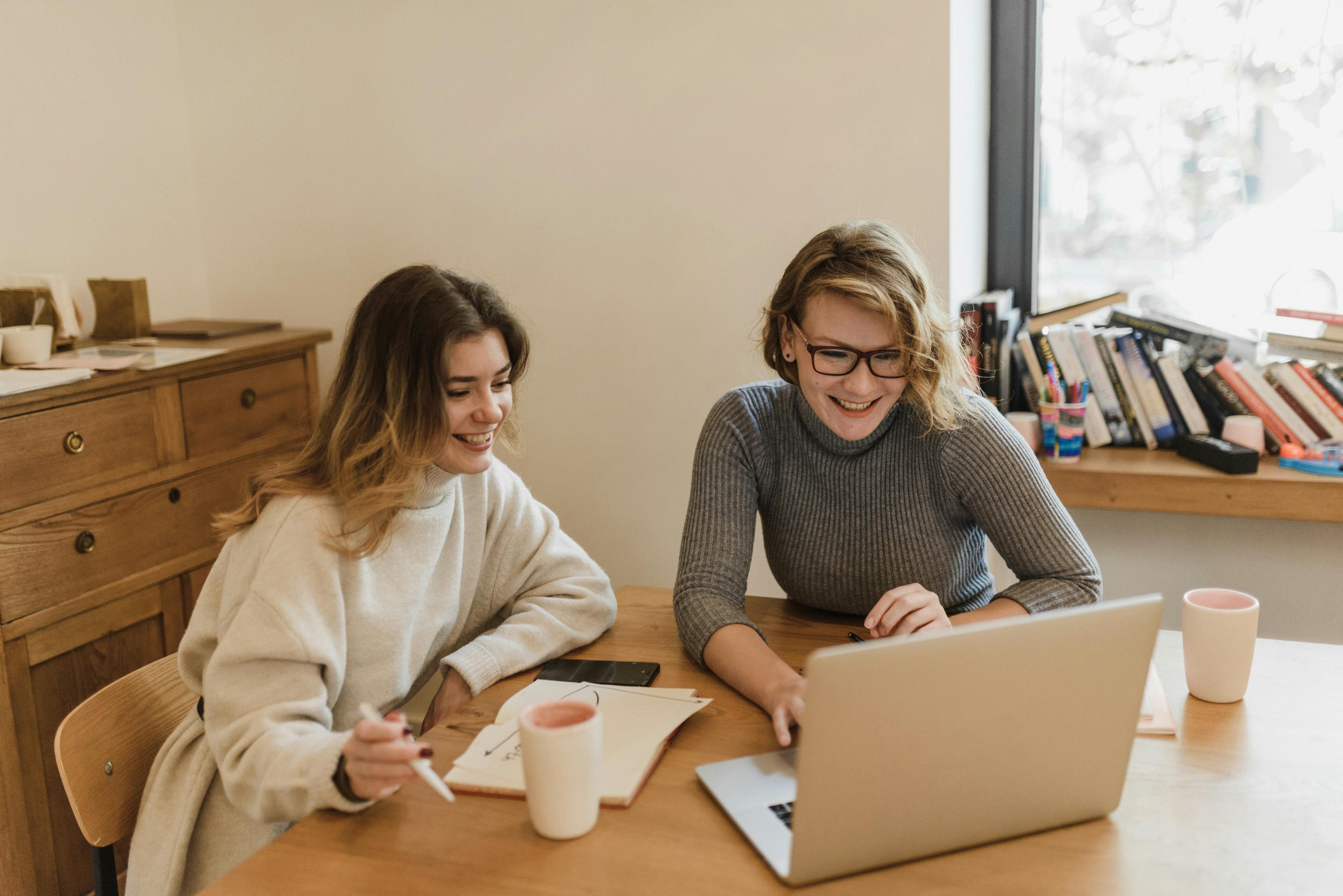 Smiling Women Sitting at Desk in Office
