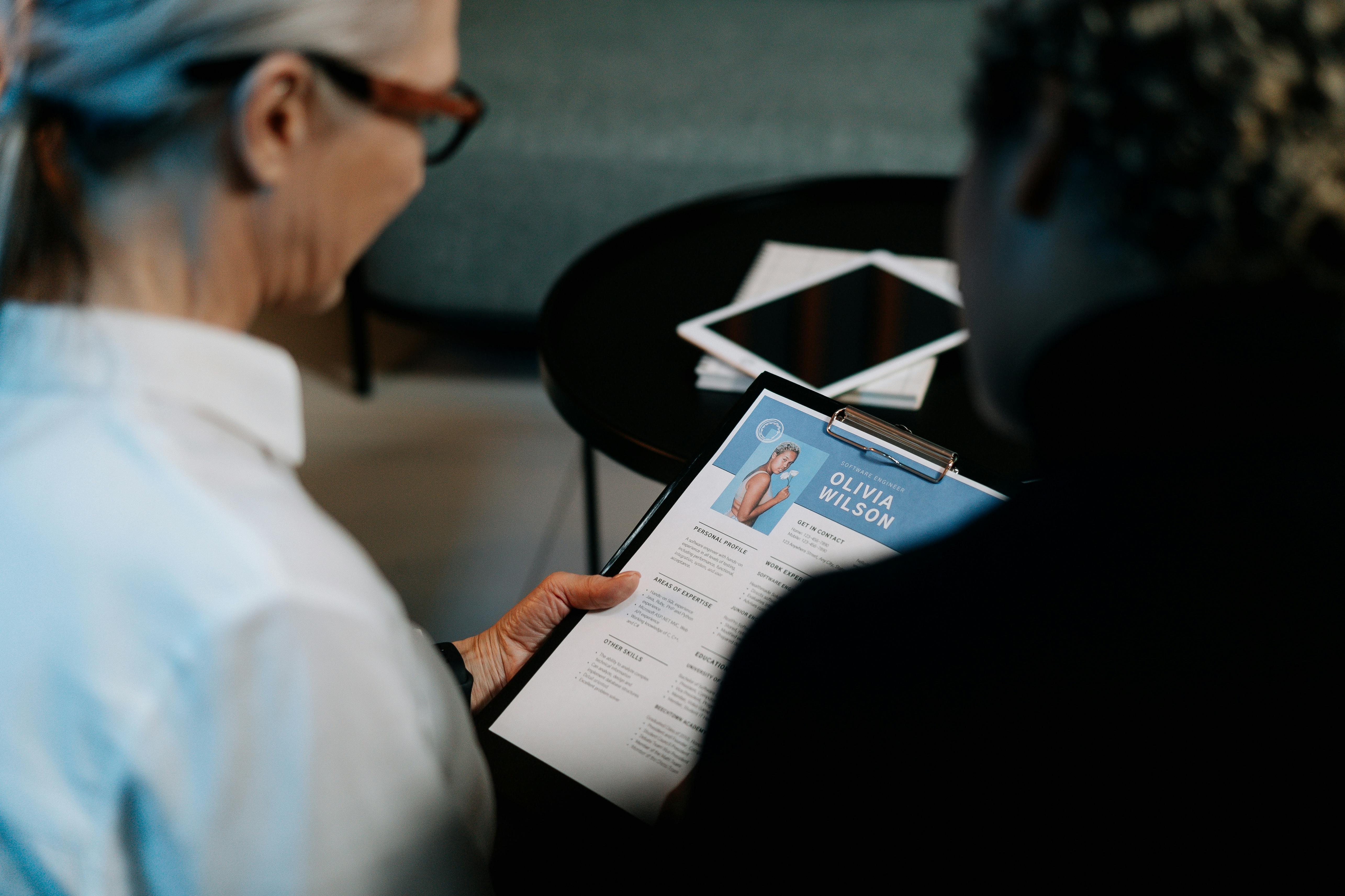 Woman Holding a Clipboard with Resume