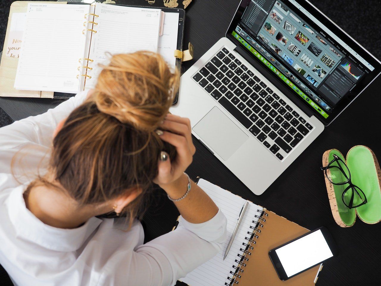 Woman with a head in her hands in front of her laptop (Performance Review)