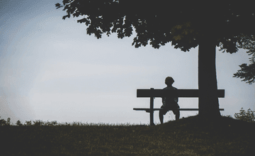 Person sitting on a bench alone.