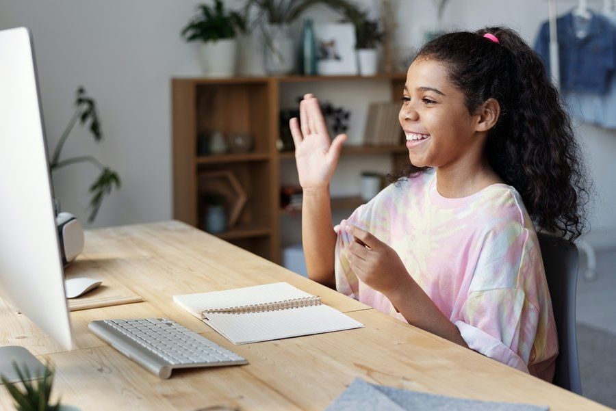 Kid smiling in front of the computer (Youth Programmes)