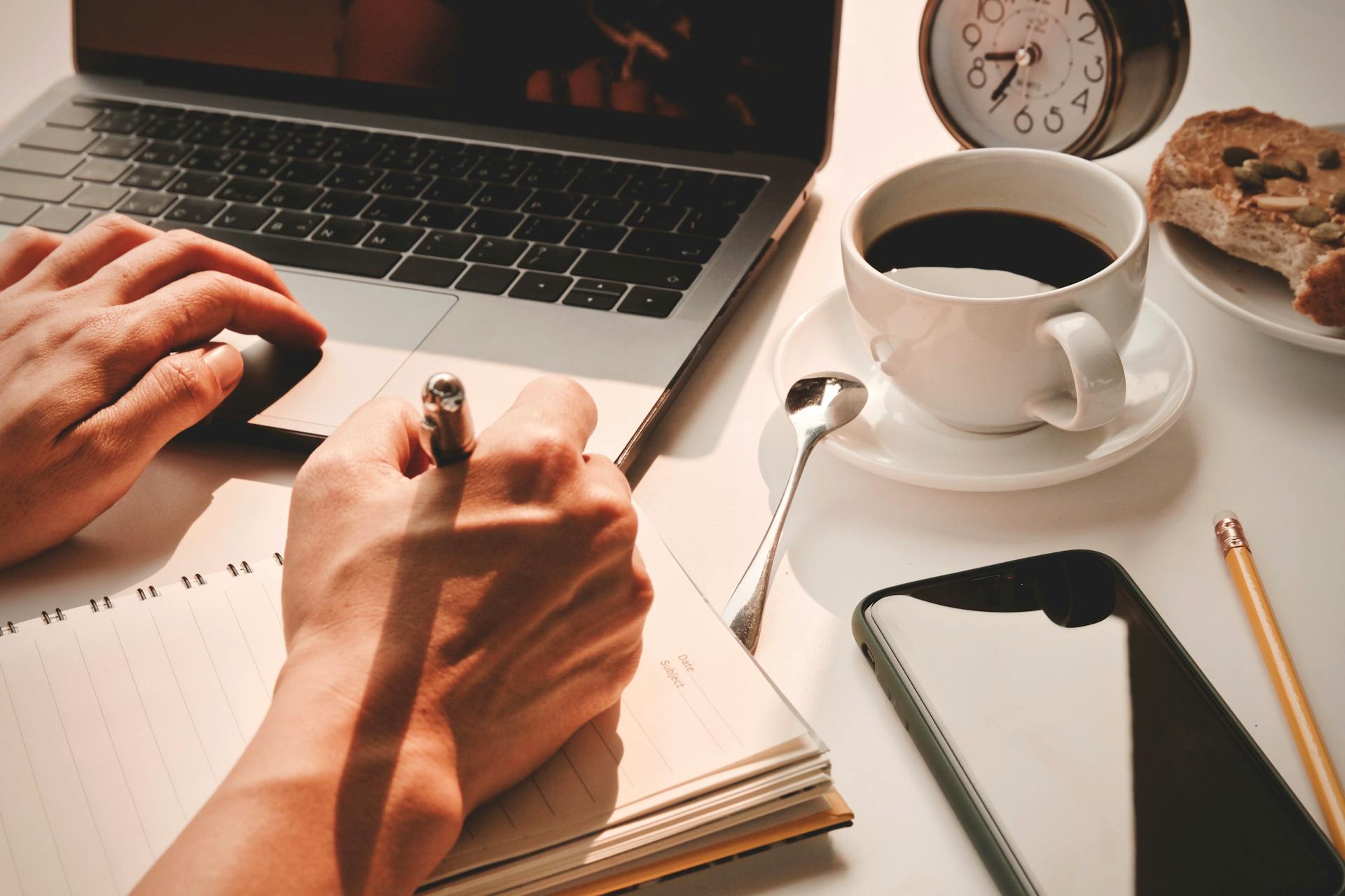 A Person Writing on a Notebook