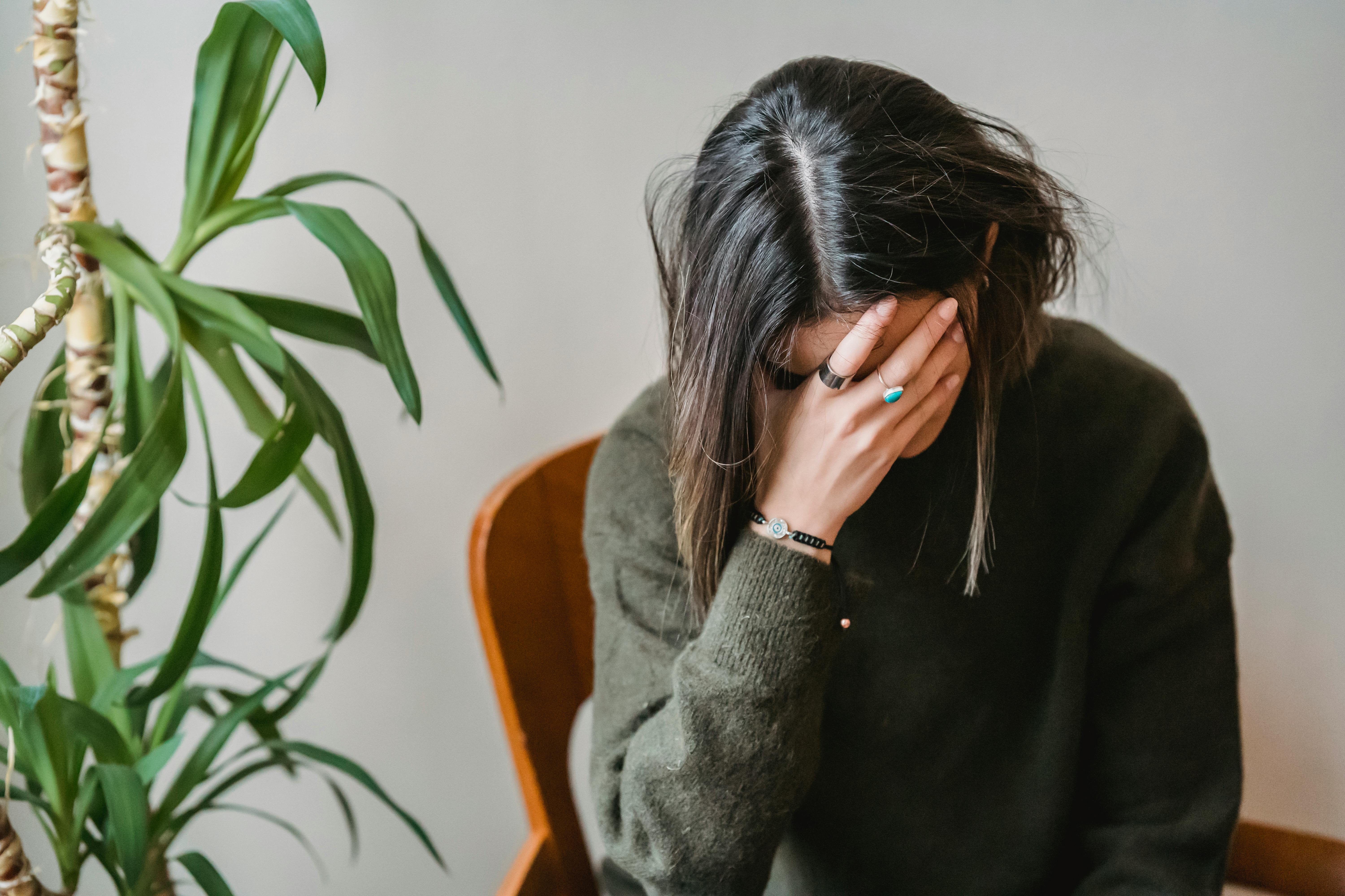 Seorang Perempuan yang Cemas Menutupi Wajahnya dengan Tangan