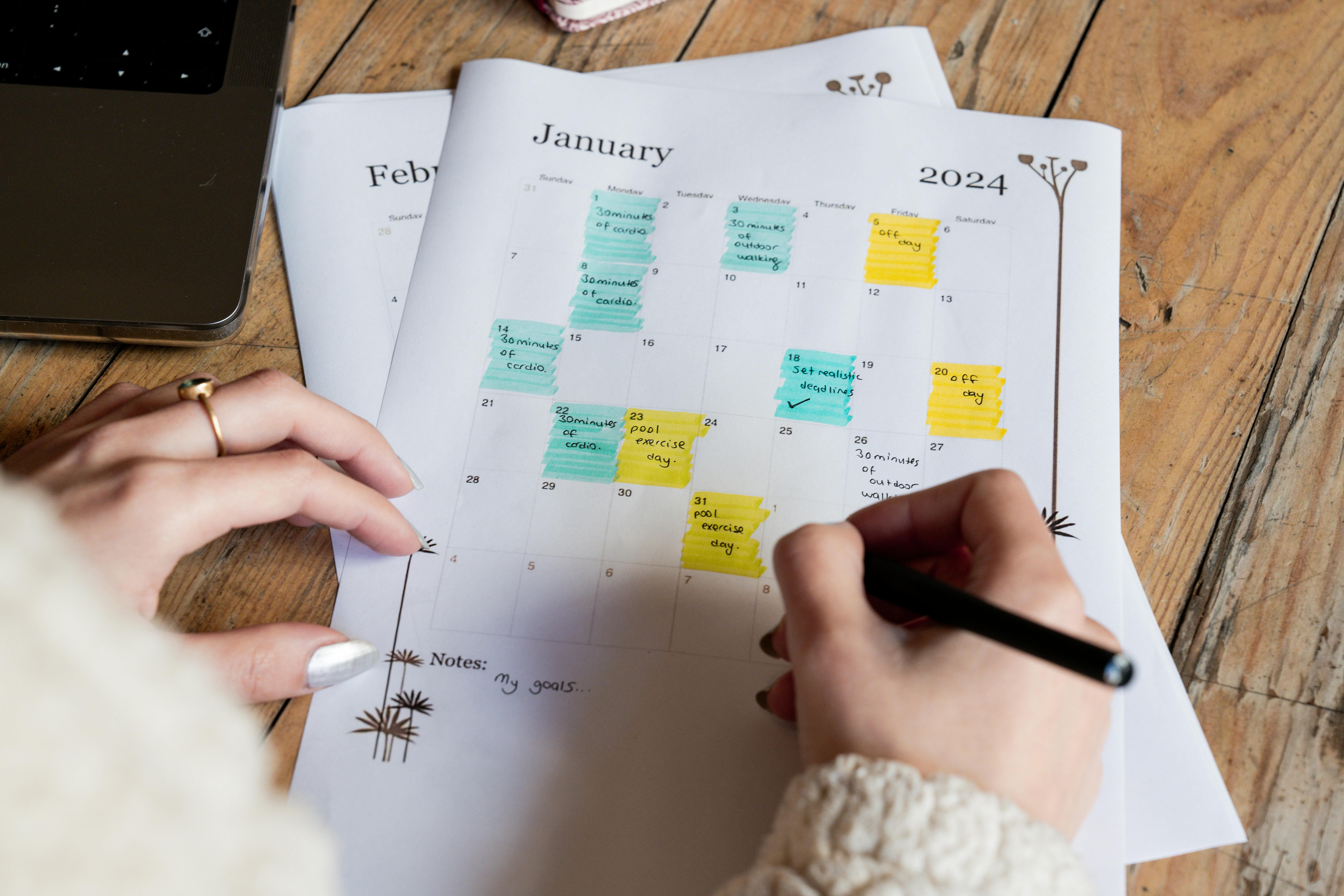 Tangan Seorang Perempuan Memegang Pena Di Atas Kalender