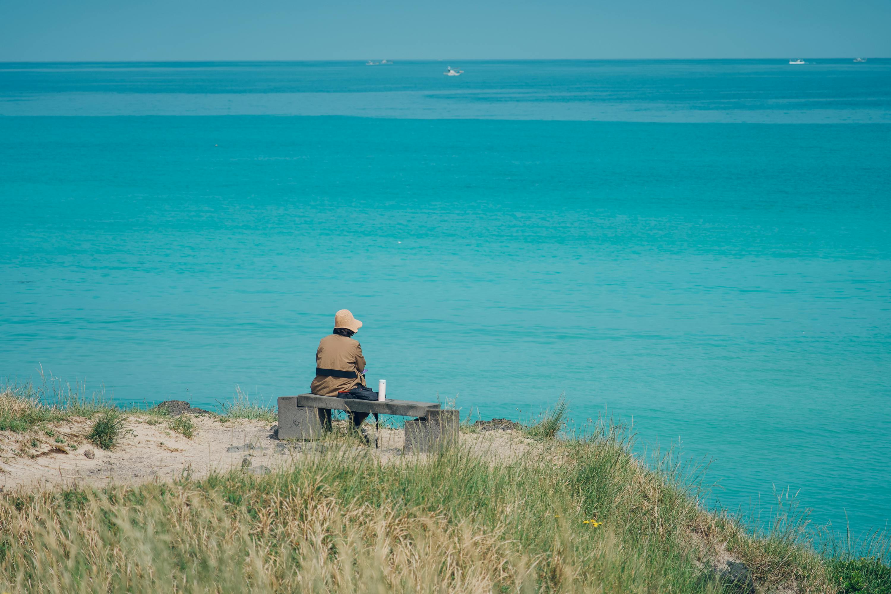 Woman Sitting on Bench near Sea