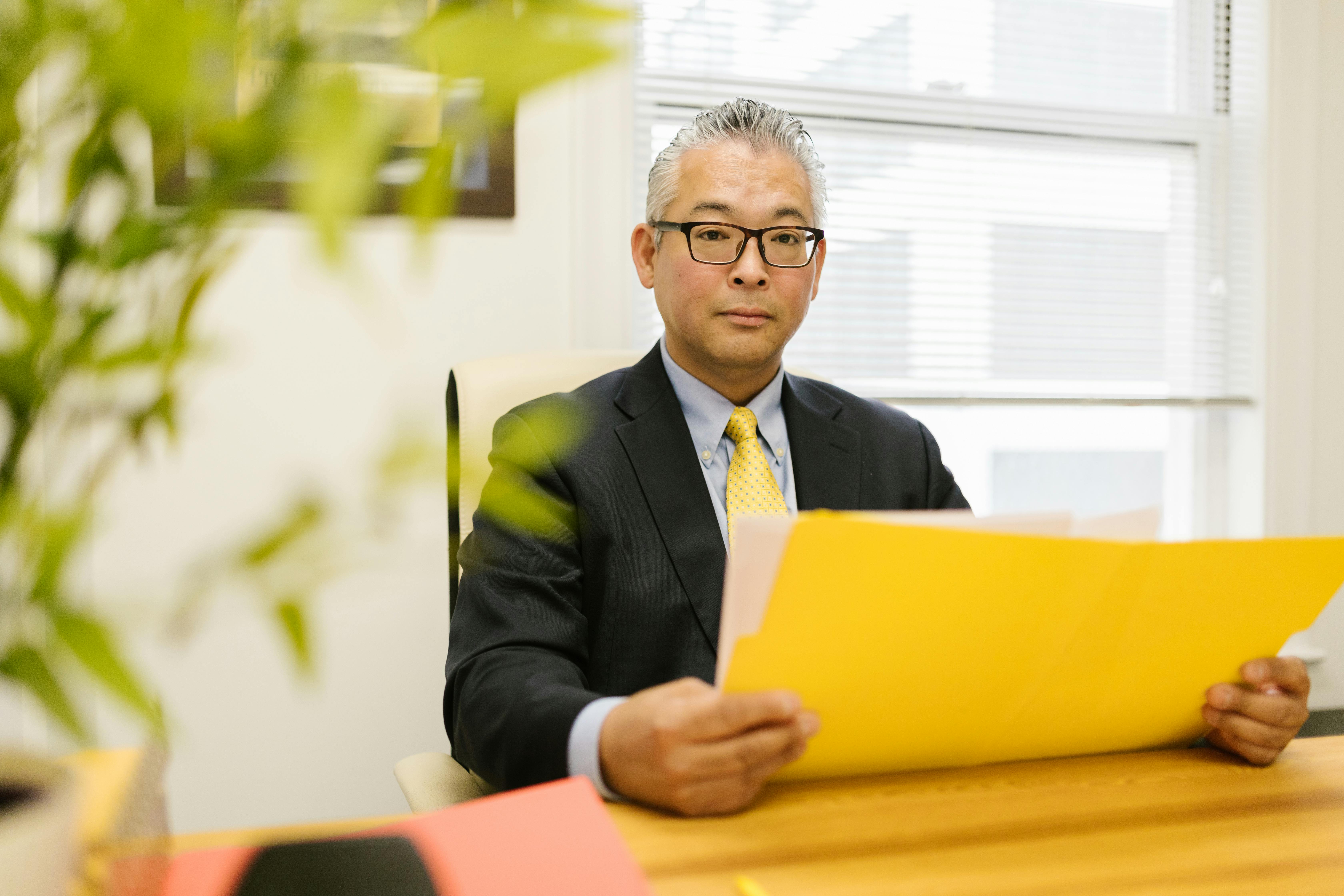 Men in black suit holding a document
