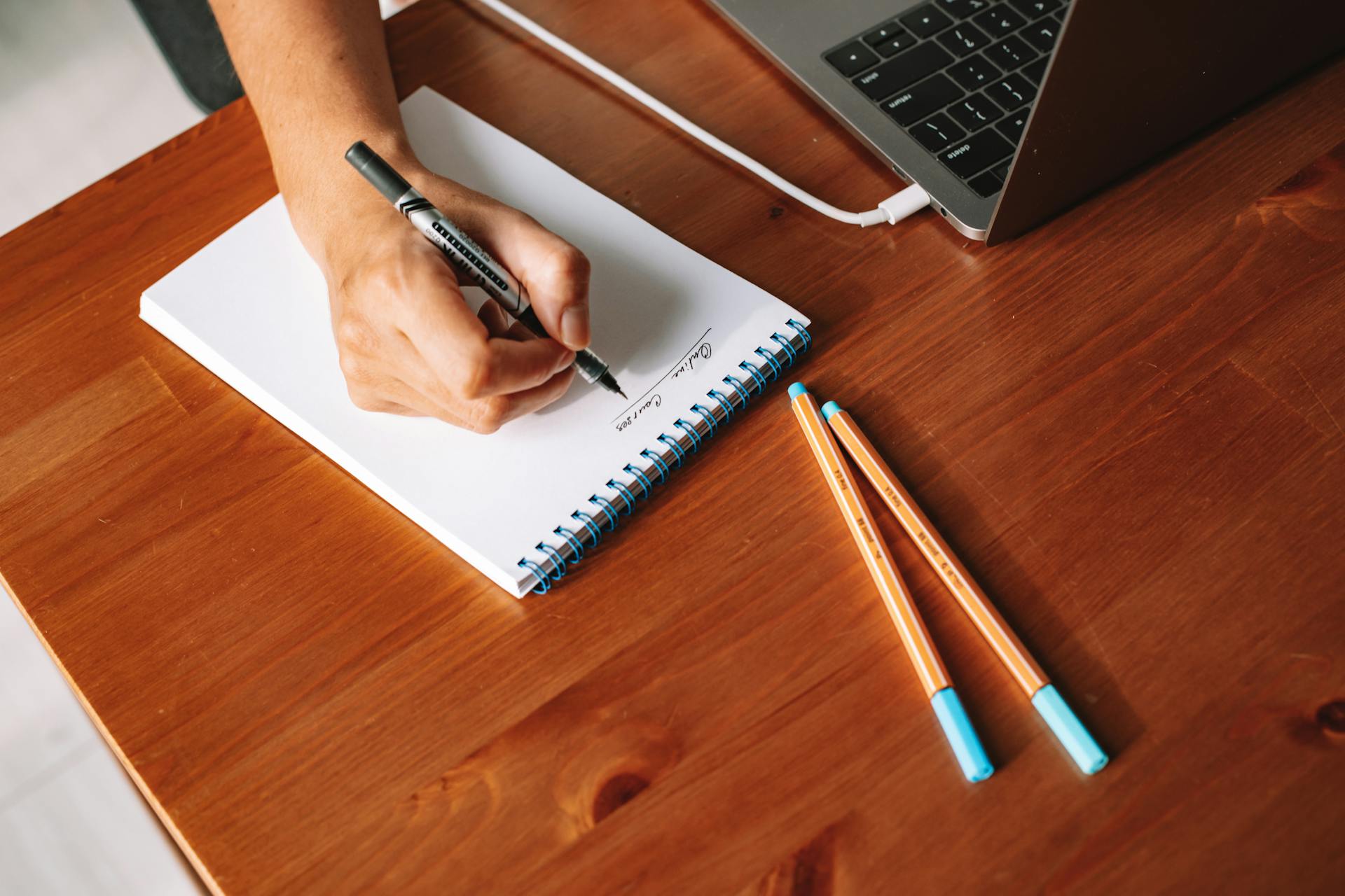 a hand writing notes on a notepad
