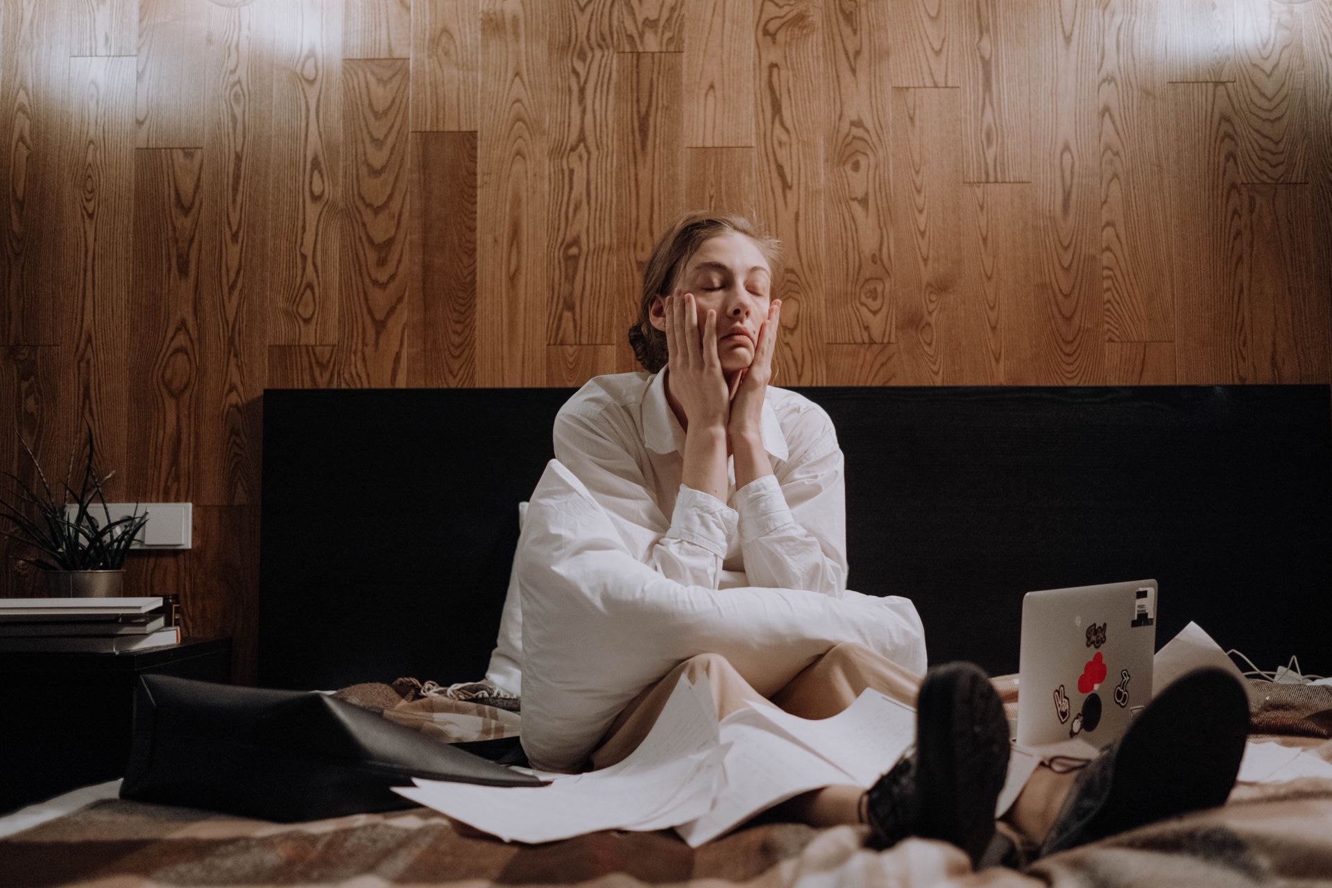 Woman sitting overwhelmed on bed
