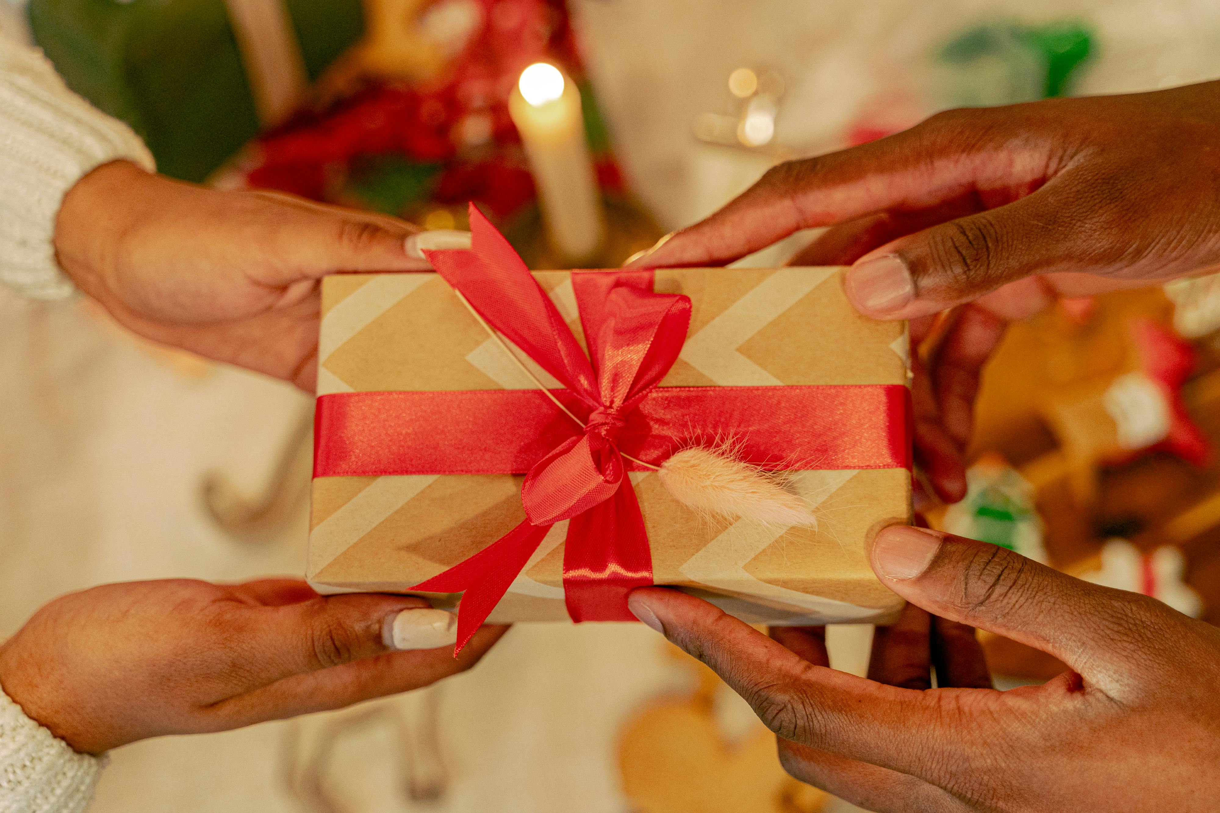 Person Holding a Box with Red Ribbon