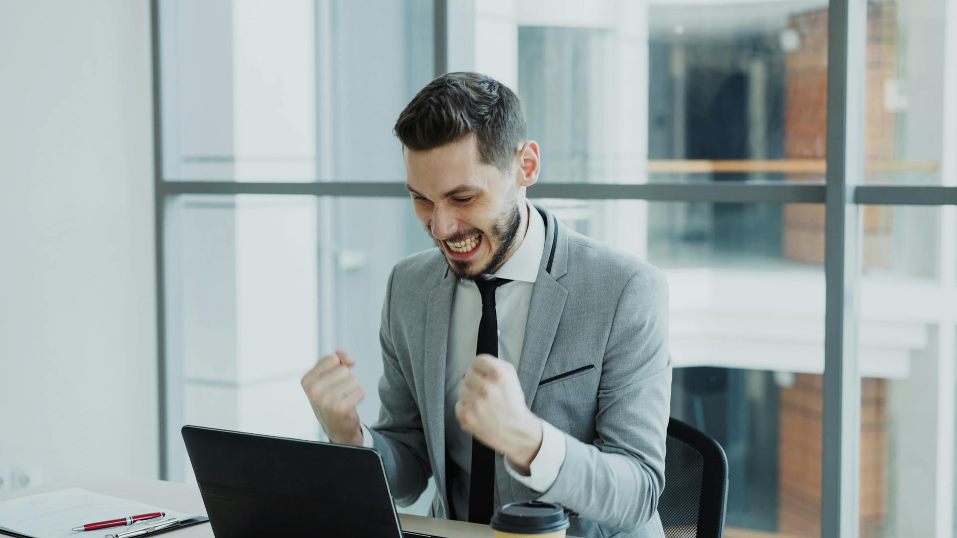 Man in grey suit celebrating success