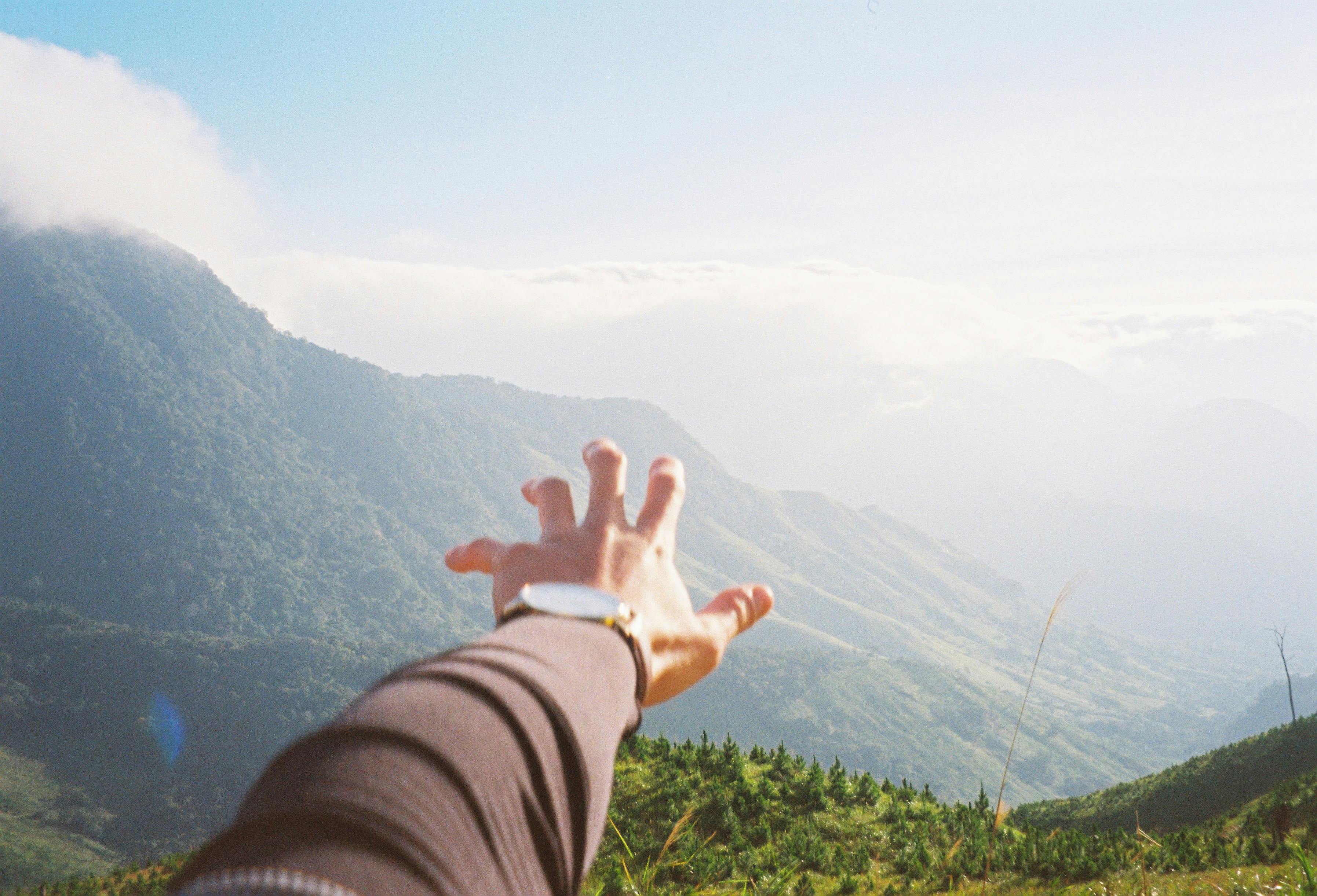 Tangan Terulur ke Arah Pemandangan Gunung