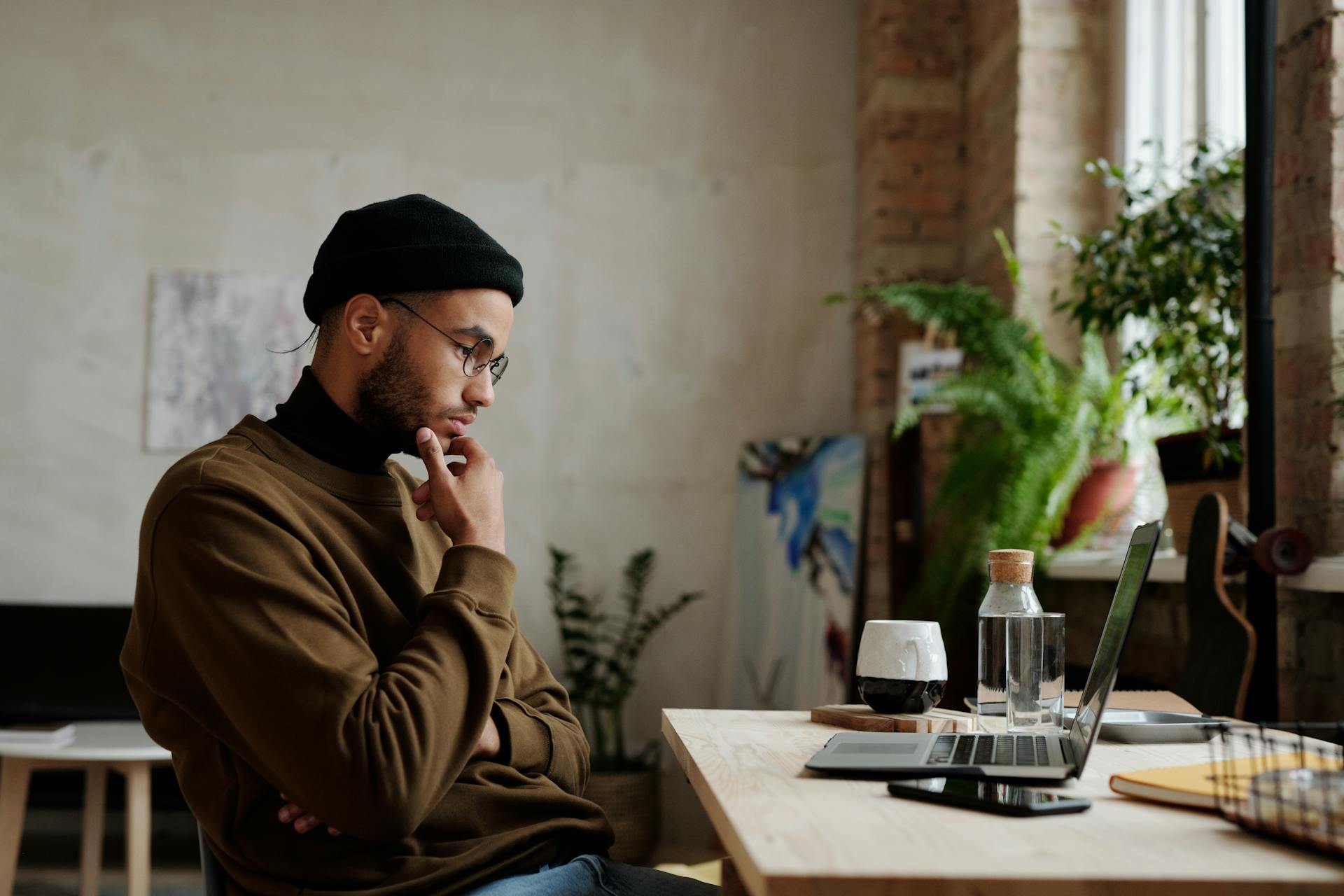 a man thinking in front of his laptop