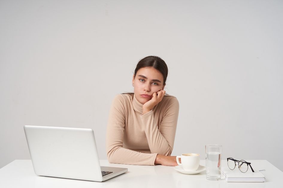 Young lady, exhausted, disengaged at work, quiet quitting at work