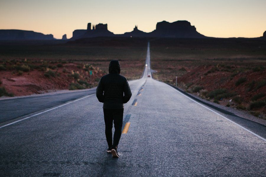 A man walking on the middle of an empty road (Motivation)