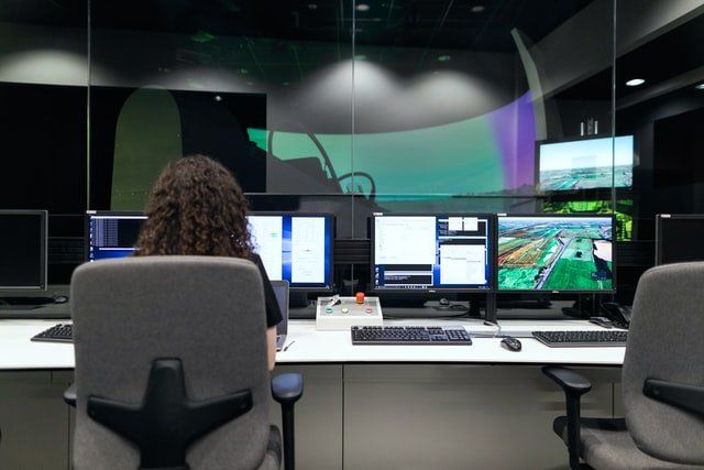 woman sitting in front of multiple desktops