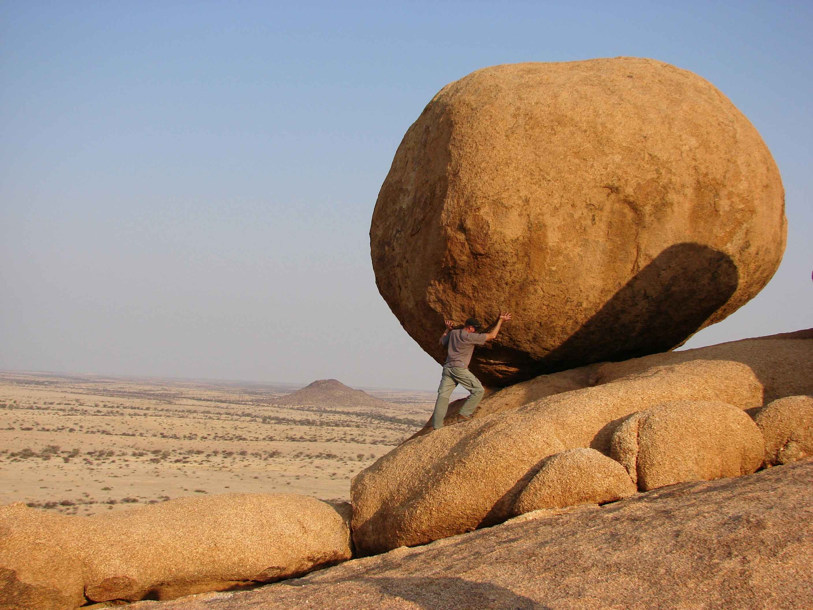 man pushing a rock